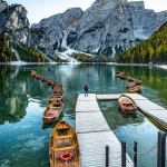 Dolomiten Fotoreisen Landschaftsfotografie, Lago di Braies im Herbst, Frau auf Steg, Holz Bote, Berge