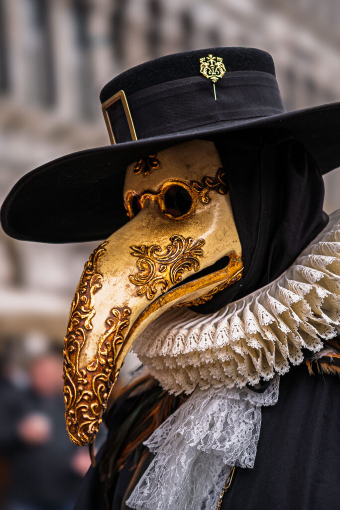 Goldene Pestmaske beim Karneval Venedig im Abendlicht